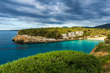 Naklejka premium Cala Romantica Bay in Mallorca with Turquoise Water Cliffs and Dramatic Sky 