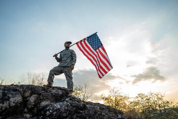 Hand Waving the Flag of the United States of America in memorial day . Us soldier holding American...