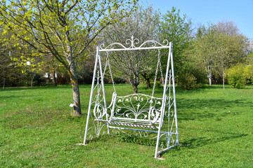 Elegant swing bench in vintage style in the garden
