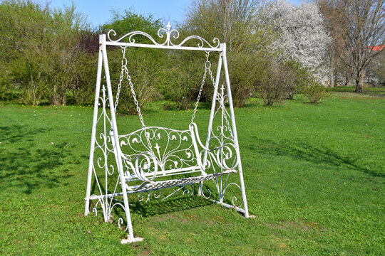 Elegant swing bench in vintage style in the summer garden