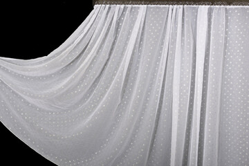 White curtain isolated on black background. Wave fabric, textile, cloth, delicate textured material. 