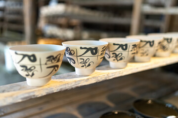 Captivating Showcase of Artisan Bowls with Elegant Calligraphy in a Rustic Setting