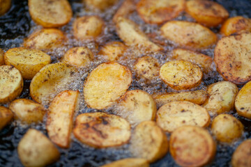 Round slices of potato are fried in oil