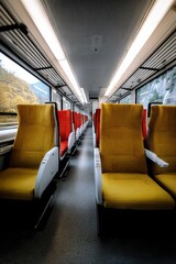 Fototapeta premium Brightly colored train seats in a quiet cabin during a scenic journey through picturesque landscapes