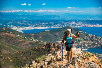Female hiker hiking the impressive red mountain of Cap Roux at the Massif de L'Esterel on the...