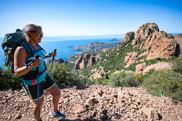 Female hiker hiking the impressive red mountain of Cap Roux at the Massif de L'Esterel on the...