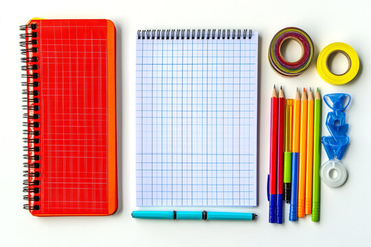 Colorful school supplies notebook pens pencils and tape arranged on white background