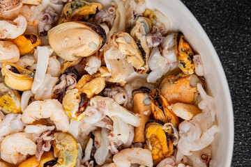 Seafood mix frut de mer mussels, shrimp, prawn, rapan, squid dish fresh gourmet food background on the table rustic food top view copy space keto  paleo diet vegetarian pescetarian diet