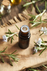 A dark bottle of rosemary essential oil on a table