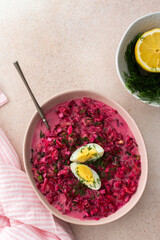Summer cold beetroot soup made from beets, radishes, cucumbers, potatoes and herbs, garnished with egg, a refreshing summer lunch