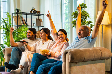Cheering for TV show, Indian family of four watches together with joy and excitement at home