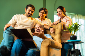 Viewing nostalgic family pictures, Indian parents and grownup kids share a joyful bonding moment