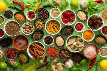A colorful assortment of fresh, fragrant spices and herbs displayed on a soft green background, capturing a vibrant culinary essence