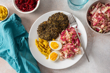 A vibrant, healthy breakfast with quinoa pancakes, crisp cabbage, radish, and mung bean sprouts, complemented by boiled eggs, hummus, and beets for a nutrient-packed meal
