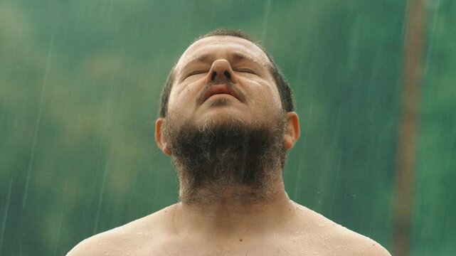 A man yells into the storm, soaked and trembling, his voice carried by wind and rain in a desperate release of pain, passion, and power.