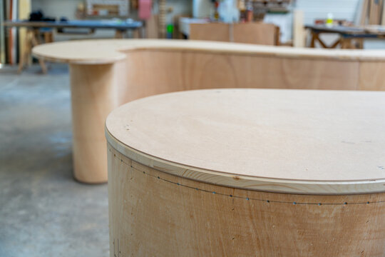 Meuble en bois aux formes arrondies fabriqu&eacute; artisanalement dans un atelier de menuiserie, mettant en valeur le savoir-faire traditionnel et le design contemporain.