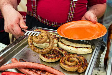 chef taking meat sausages on a paper plate