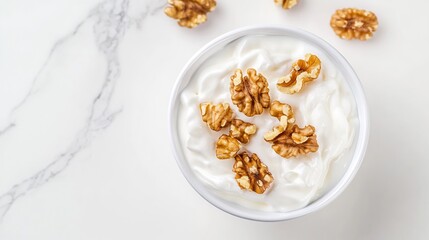 Greeces traditional Greek yogurt honey and walnuts served in a bowl captured from above with a white marble backdrop