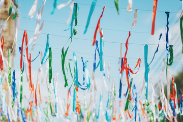 Colorful ribbons sway in the breeze above a vibrant festival celebrating local culture and heritage in a sunny outdoor location during the afternoon hours