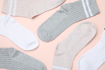 Many different pairs of socks on beige background, flat lay