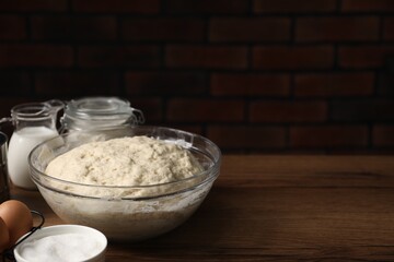 Raw dough and ingredients on wooden table, closeup. Space for text