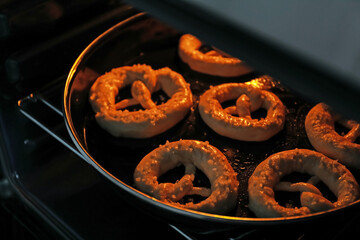 Fototapeta na wymiar Baking dish with pretzels in oven, closeup