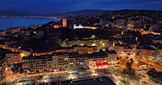 Aerial video in Cannes with a view of the beach and luxurious buildings at Night. Prestigious nightlife in Cannes. Cannes renowned for best colorful venues at night on the Cote Azur, French Riviera