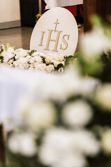 IHS Monogram Displayed in Church During First Holy Communion Ceremony