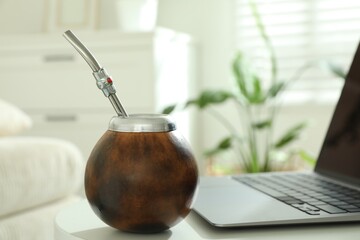 Traditional yerba mate tea and laptop on white table indoors