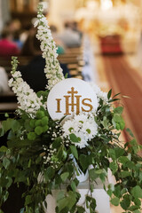 IHS Monogram Displayed in Church During First Holy Communion Ceremony