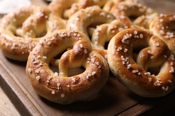 Many tasty salted pretzels on table, closeup