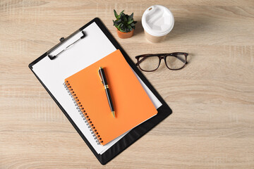 Flat lay composition with office supplies, houseplant and takeaway paper cup on wooden table
