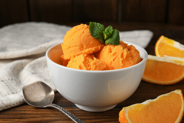 Tasty orange sorbet, fresh fruits and mint on wooden table, closeup