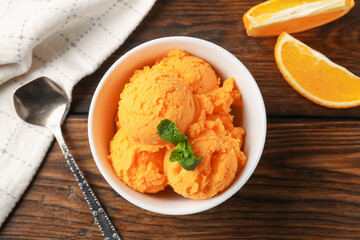 Tasty orange sorbet, fresh fruits and mint on wooden table, flat lay