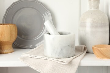 Marble mortar and pestle on white table indoors, closeup