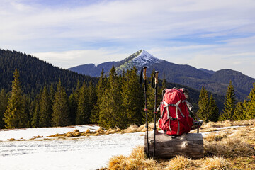 Picturesque view of mountain peaks, backpack with trekking poles against the backdrop of...