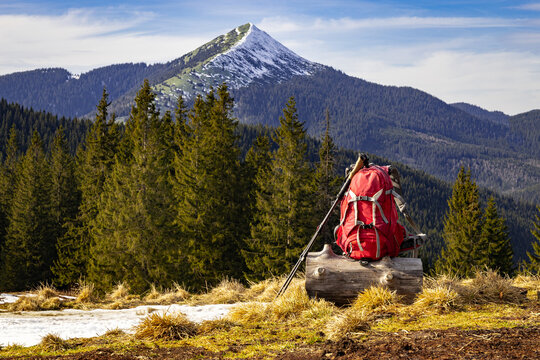 Picturesque view of mountain peaks, backpack with trekking poles against the backdrop of snow-capped peaks.
