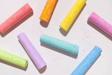 Multicolored bright crayons for drawing on light gray background flat lay top view. Children's chalk close-up. Concept of creativity, child development, back to school