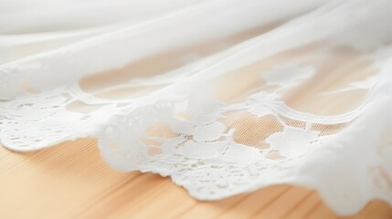 Delicate white lace trim adorns sheer fabric, resting on light wood.  Intricate floral patterns highlight the craftsmanship