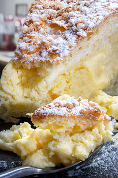 A slice of tarte tropezienne and a spoonfull of cake on black slate.