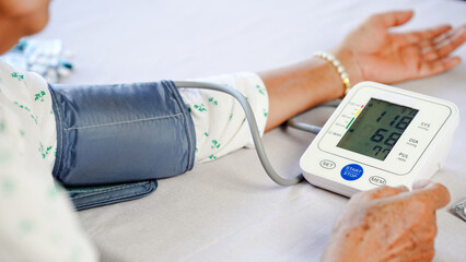 Blood pressure monitor, elderly woman, healthcare, medical device, arm cuff, digital display, home...