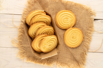 Shortbread sweet cookies with kitchen utensils on a wooden table, close-up, top view.