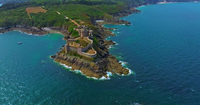 Aerial view of Fort La Latte, Chateau de la Roche Guyon in Cap Frehel, Brittany, France, on a sunny day in summer with waves crushing on the sandstone cliffs