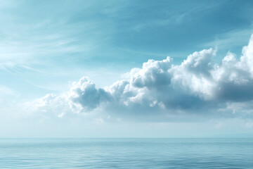 Fototapeta premium Soft billowy clouds float above peaceful sea, creating tranquil and serene atmosphere with gentle blue tones and calm water reflections
