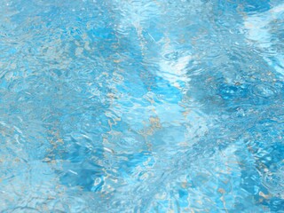 Fondo abstracto,agua en una pequeña piscina con olas y reflejos de luz solar