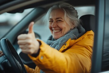 Happy senior woman driving car giving thumbs up