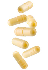Yellow capsule pills falling in space. Isolated on white.