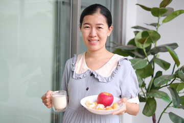 pregnant asian woman eat mixed fruits and milk