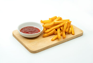 Fries  and ketchup on wood board.