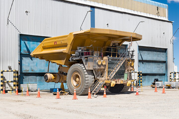 Huge mining truck in the maintenance workshop at a mining operation, with one of its giant tires removed. © Jose Luis Stephens